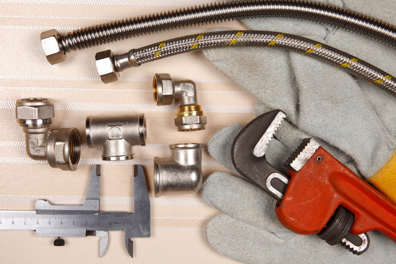 Plumber working on pipes in a Thamesmead home